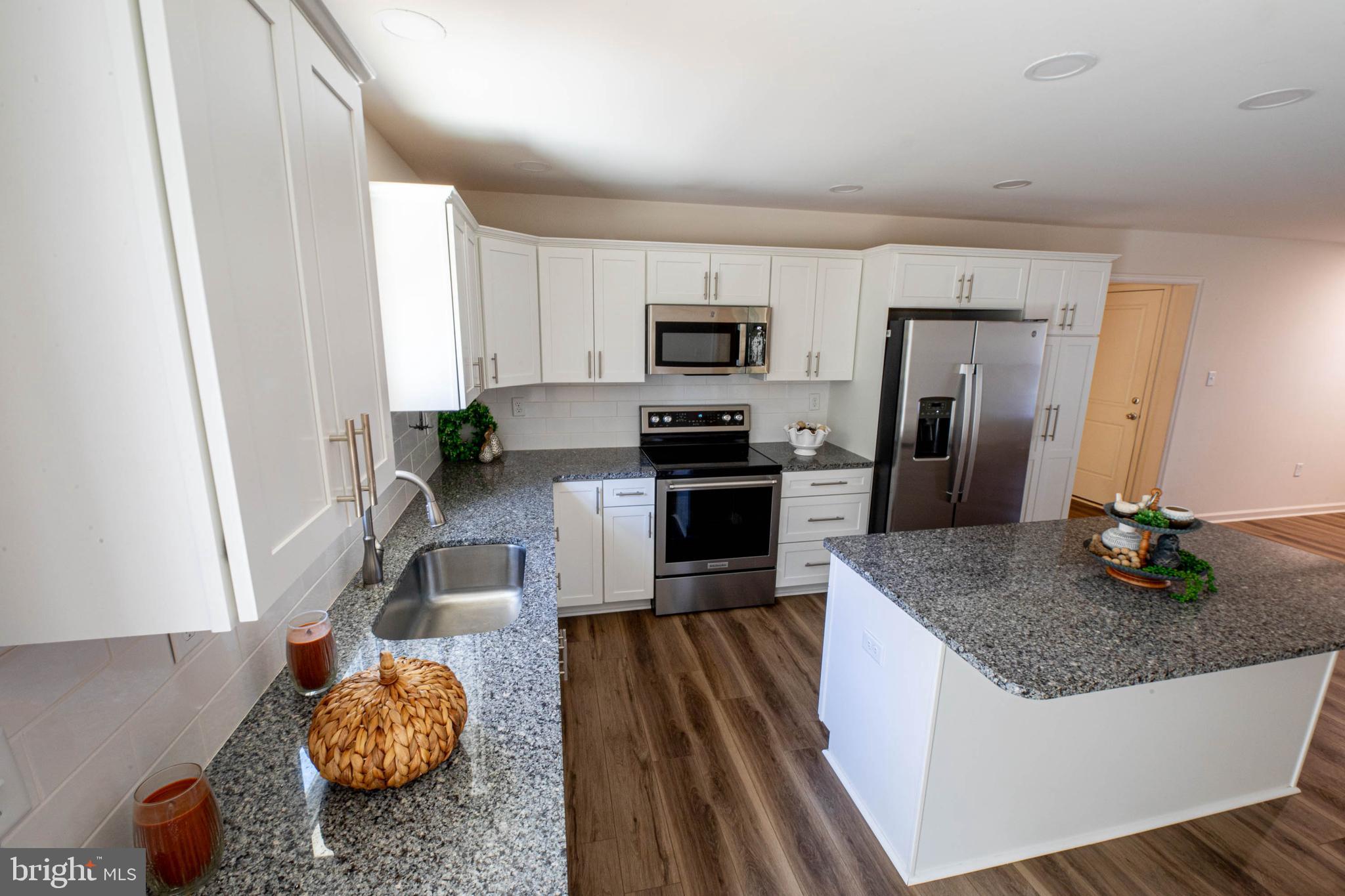 26300 Fire Tower Road Seaford, DE 19973 - Photo 13 of 52 a kitchen with stainless steel appliances granite countertop a sink refrigerator and microwave