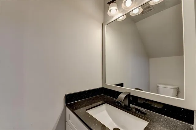 a bathroom with a sink a toilet and a mirror
