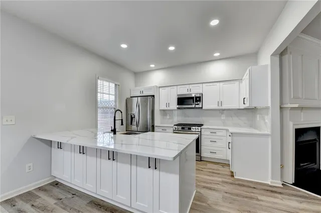 a large white kitchen with stainless steel appliances
