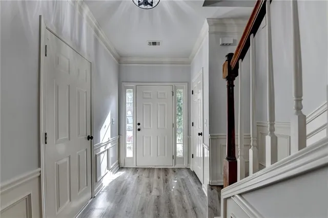 a view of a hallway with wooden floor and staircase