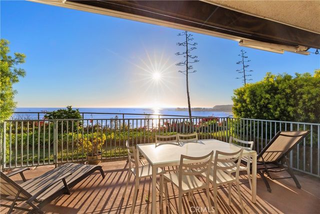 a view of a balcony with wooden floor and outdoor seating