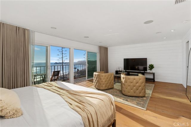 a bedroom with a bed a flat screen tv and a couch