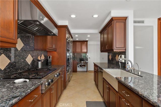 a kitchen with granite countertop a stove and a sink