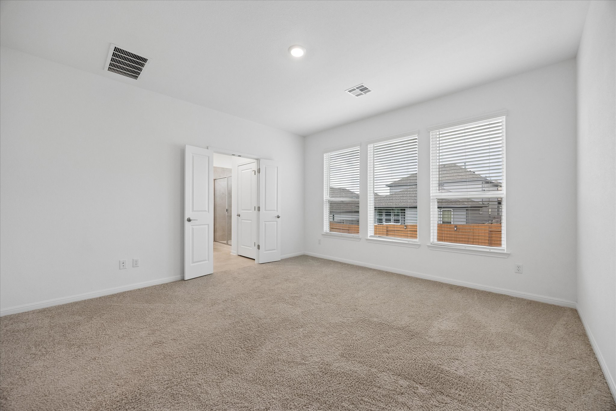 6407 Rounded Pebble Lane Buda, TX 78610 - Photo 14 of 32 A well-lit bedroom with plush carpeting and ample window views invites tranquil rest.