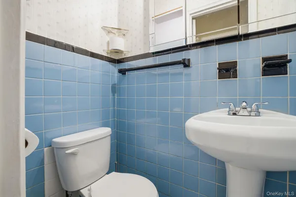 a bathroom with a sink a toilet and a mirror