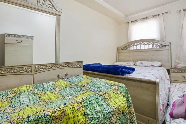 a bed sitting in a bedroom next to a window