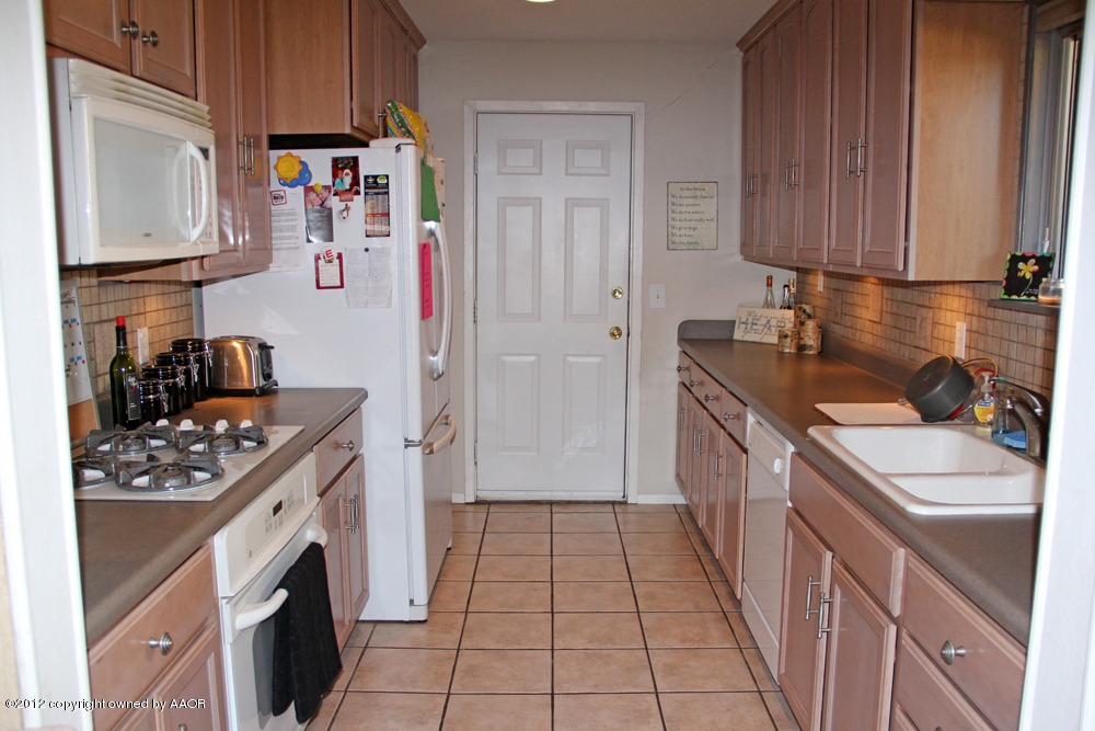 7208 Jameson Road Amarillo, TX 79106 - Photo 13 of 40 a kitchen with a sink stove and cabinets