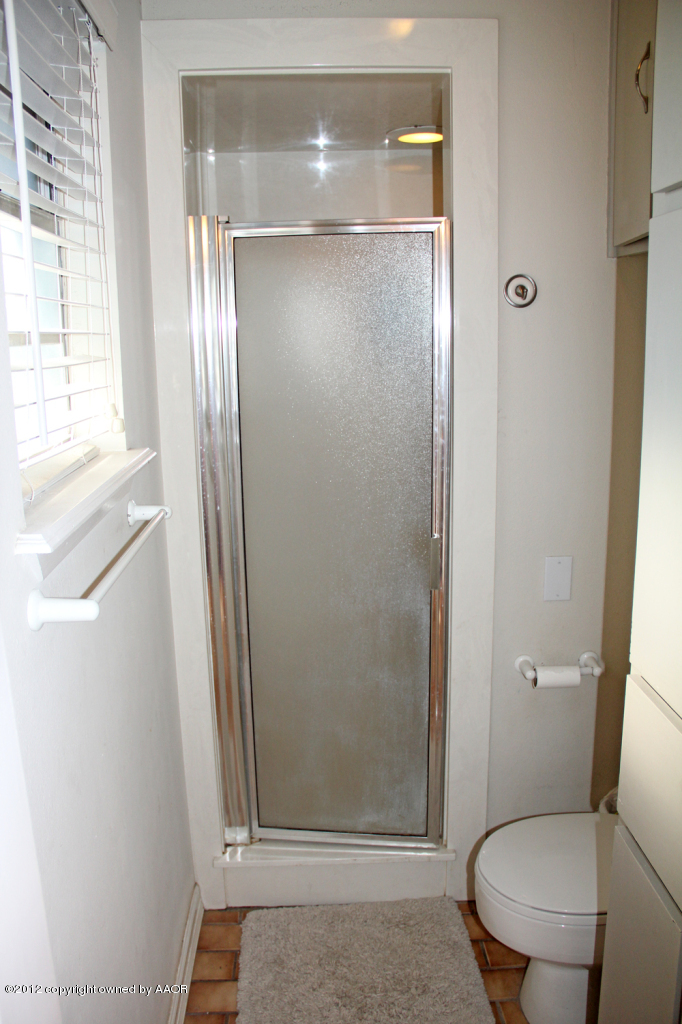 7208 Jameson Road Amarillo, TX 79106 - Photo 22 of 40 a bathroom with a glass shower door