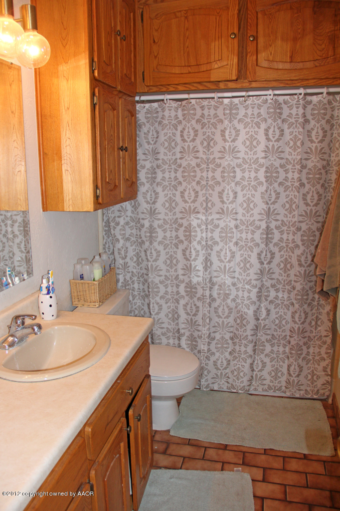 7208 Jameson Road Amarillo, TX 79106 - Photo 31 of 40 a bathroom with a sink a toilet and a mirror