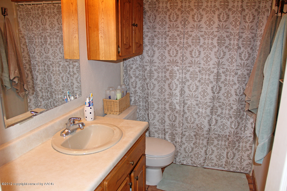 7208 Jameson Road Amarillo, TX 79106 - Photo 32 of 40 a bathroom with a sink a toilet and mirror