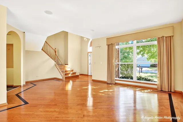 a view of empty room with wooden floor and windows