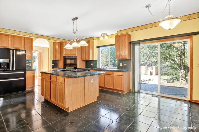 a large kitchen with kitchen island granite countertop a stove a sink and a refrigerator