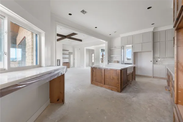 a large kitchen with stainless steel appliances kitchen island granite countertop a large counter top and white cabinets