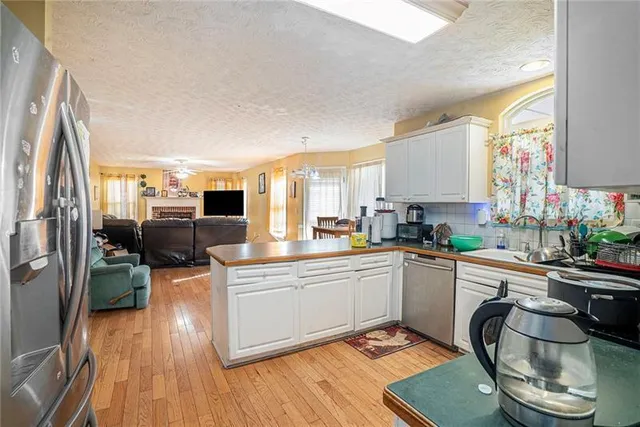 a kitchen with stainless steel appliances granite countertop a sink stove and wooden floor