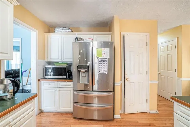 a kitchen with white cabinets and stainless steel appliances