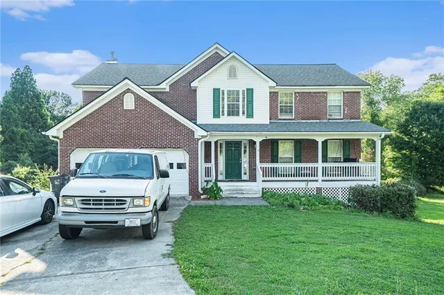 a view of a house with a yard and sitting area
