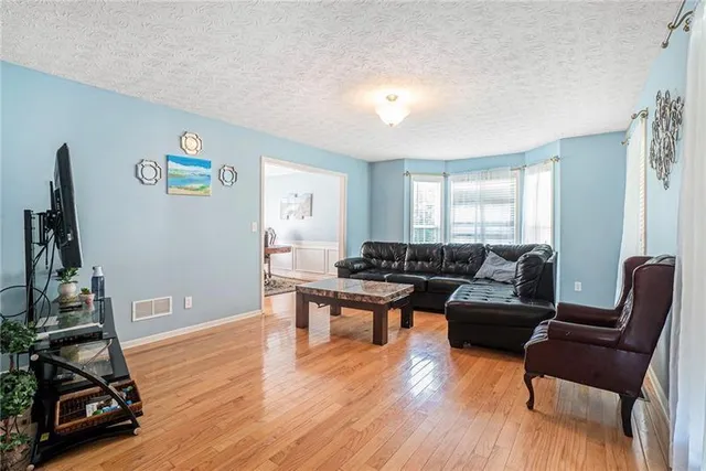 a living room with furniture a wooden floor and a flat screen tv