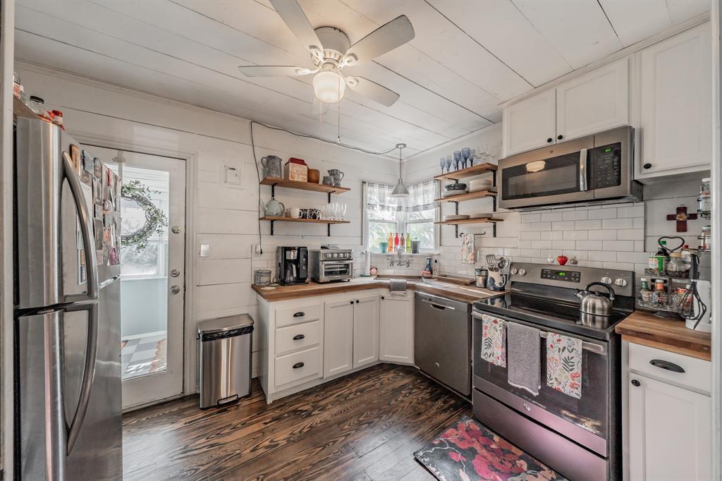 3516 Primrose Avenue Fort Worth, TX 76111 - Photo 11 of 30 a kitchen with stainless steel appliances granite countertop a refrigerator a sink dishwasher a stove and white cabinets with wooden floor