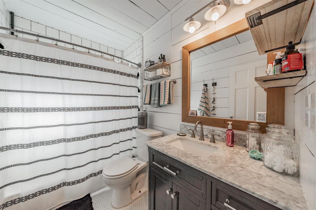 3516 Primrose Avenue Fort Worth, TX 76111 - Photo 23 of 30 a bathroom with a granite countertop toilet sink and mirror