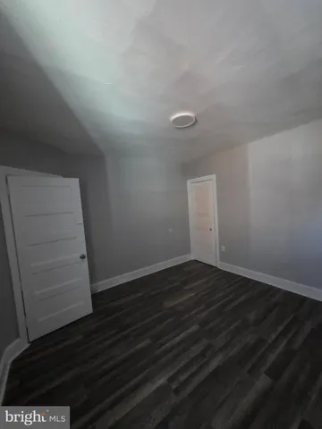 a view of a room with wooden floor and an empty room