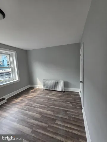 a bathroom with a toilet a sink a mirror and a window