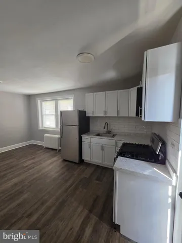 a bathroom with a granite countertop toilet a sink and a mirror