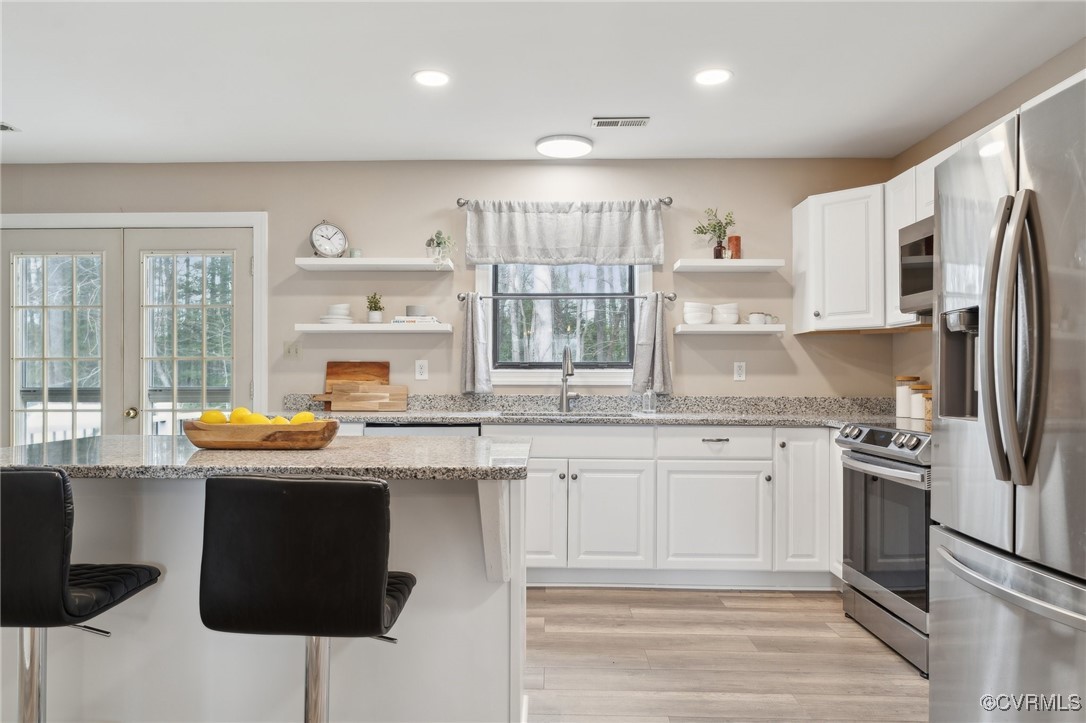17830 Stage Road Barhamsville, VA 23011 - Photo 13 of 48 Kitchen with open shelves, white cabinets, visible