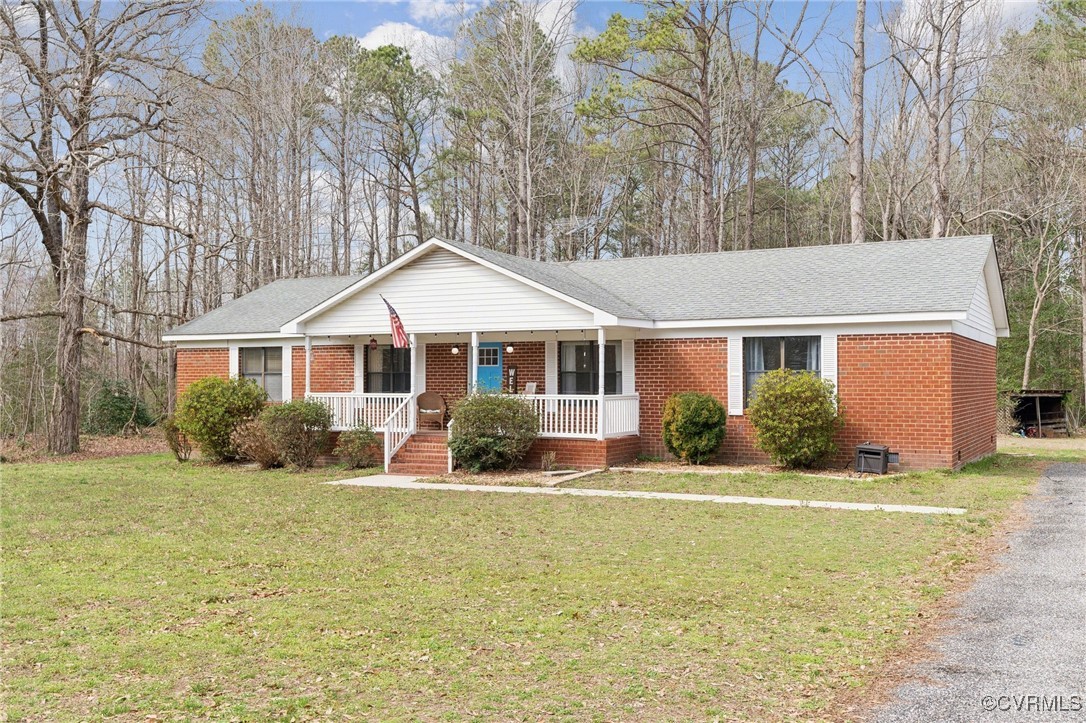 Ranch-style home with a porch, brick siding, a fro