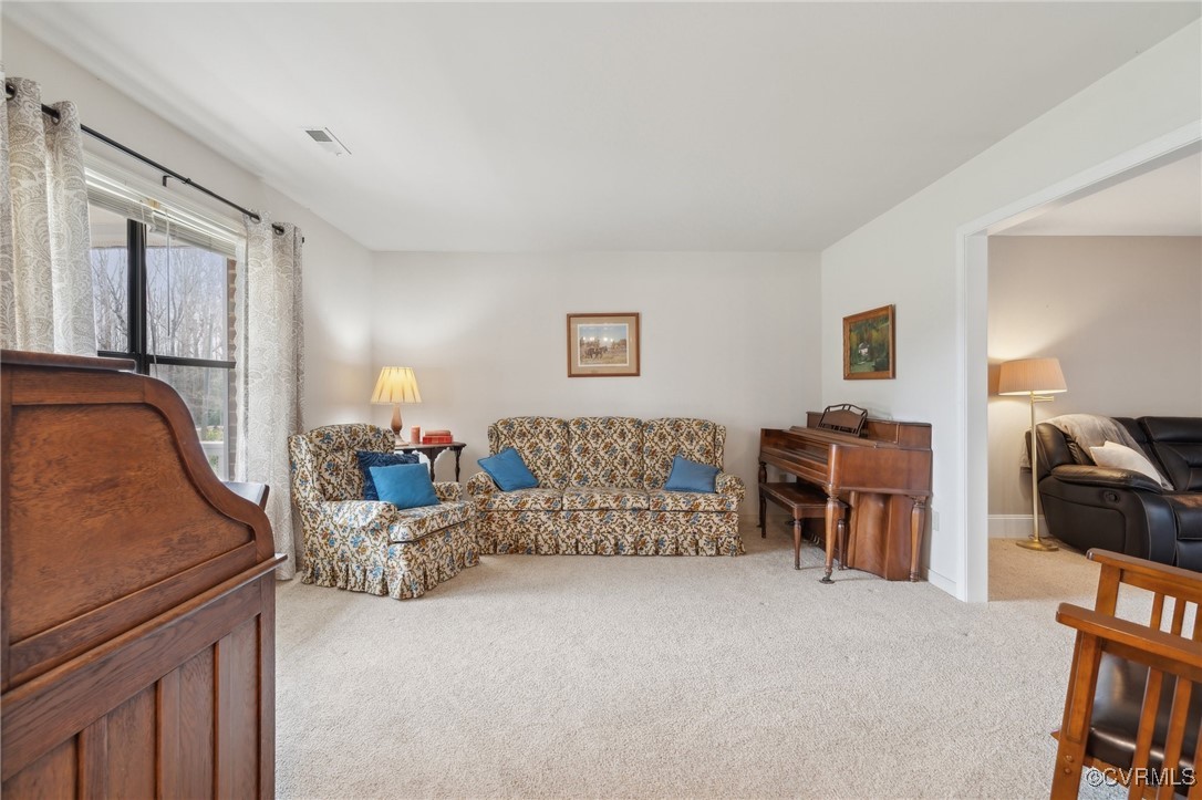 Living area with visible vents, baseboards, and ca