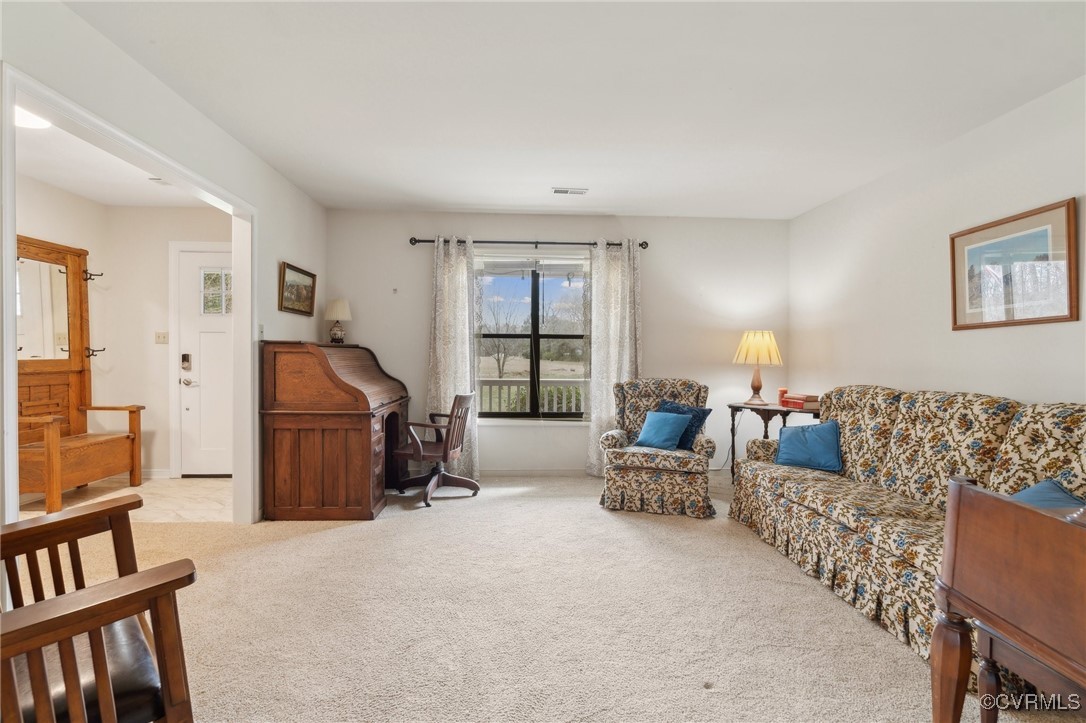 Carpeted living area featuring baseboards