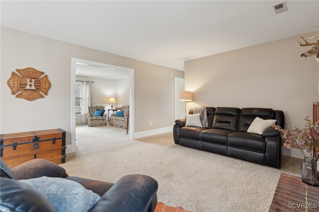 Carpeted living area featuring visible vents and b