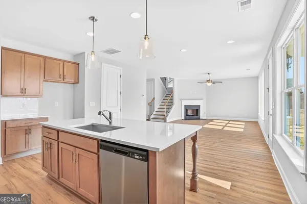 a large white kitchen with wooden floors and a fireplace