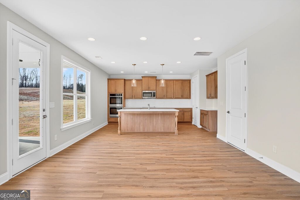 152 Classic Overlook Homer, GA 30547 - Photo 12 of 36 a large white kitchen with wooden floors and a fireplace