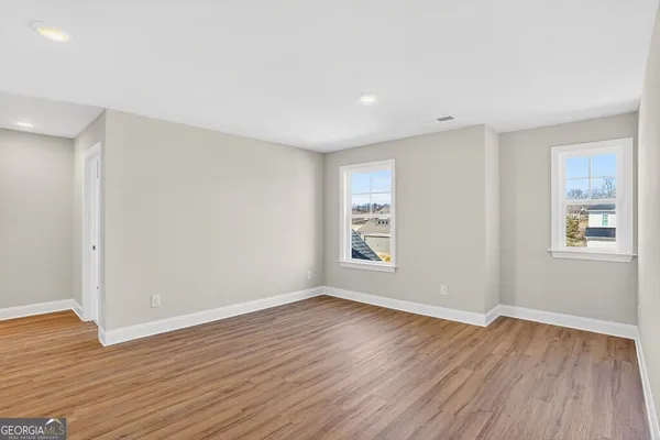 a view of empty room with wooden floor