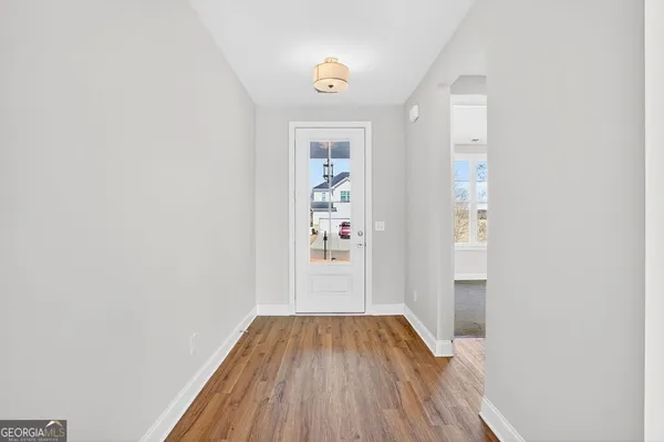 a view of a hallway view with wooden floor and staircase