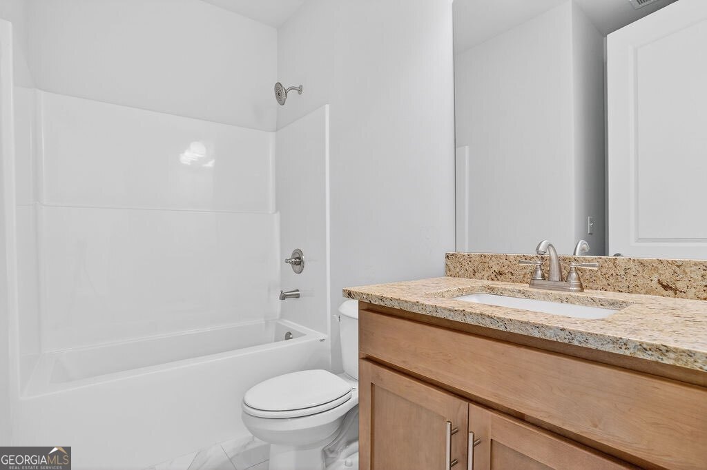 152 Classic Overlook Homer, GA 30547 - Photo 4 of 36 a bathroom with a granite countertop sink toilet mirror vanity and bathtub