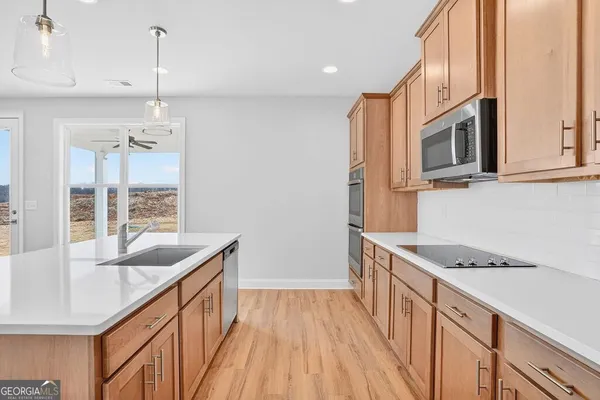 a kitchen with granite countertop a sink stove and cabinets