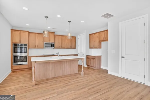 a large kitchen with stainless steel appliances granite countertop a stove a sink and a refrigerator