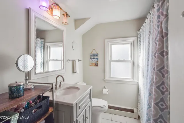 a bathroom with a granite countertop sink a toilet and a mirror
