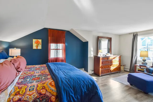 a bedroom with a bed and dresser with mirror