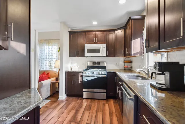 a kitchen with stainless steel appliances granite countertop a refrigerator stove microwave and sink