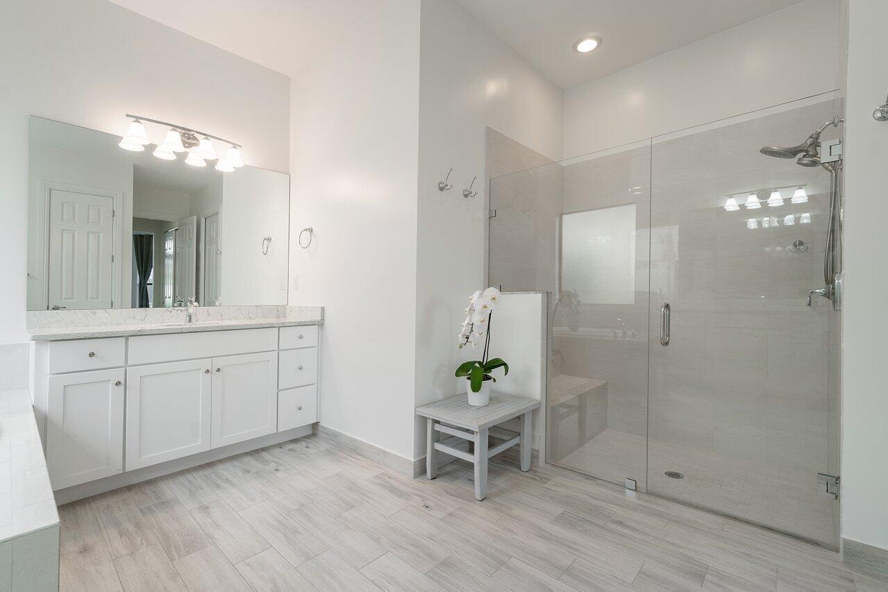11856 Leon Circle Parkland, FL 33076 - Photo 11 of 43 a spacious bathroom with a granite countertop sink a mirror and shower