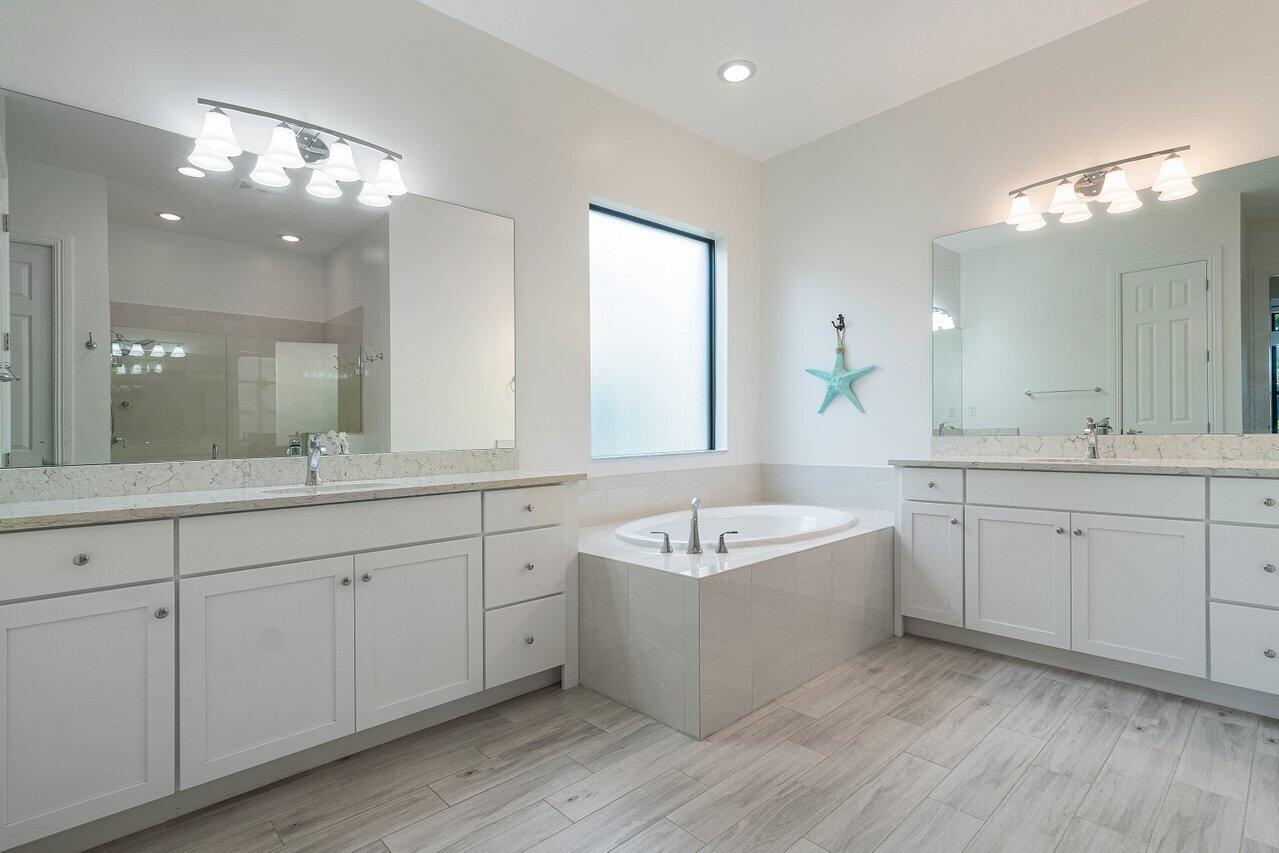 11856 Leon Circle Parkland, FL 33076 - Photo 12 of 43 a spacious bathroom with a double vanity sink a large mirror and bathtub