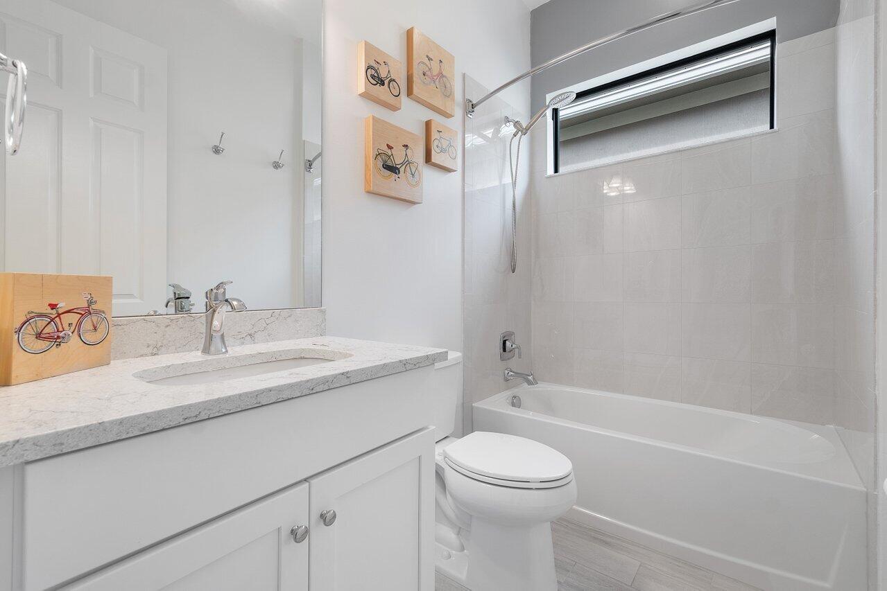 11856 Leon Circle Parkland, FL 33076 - Photo 15 of 43 a bathroom with a granite countertop sink a toilet and shower