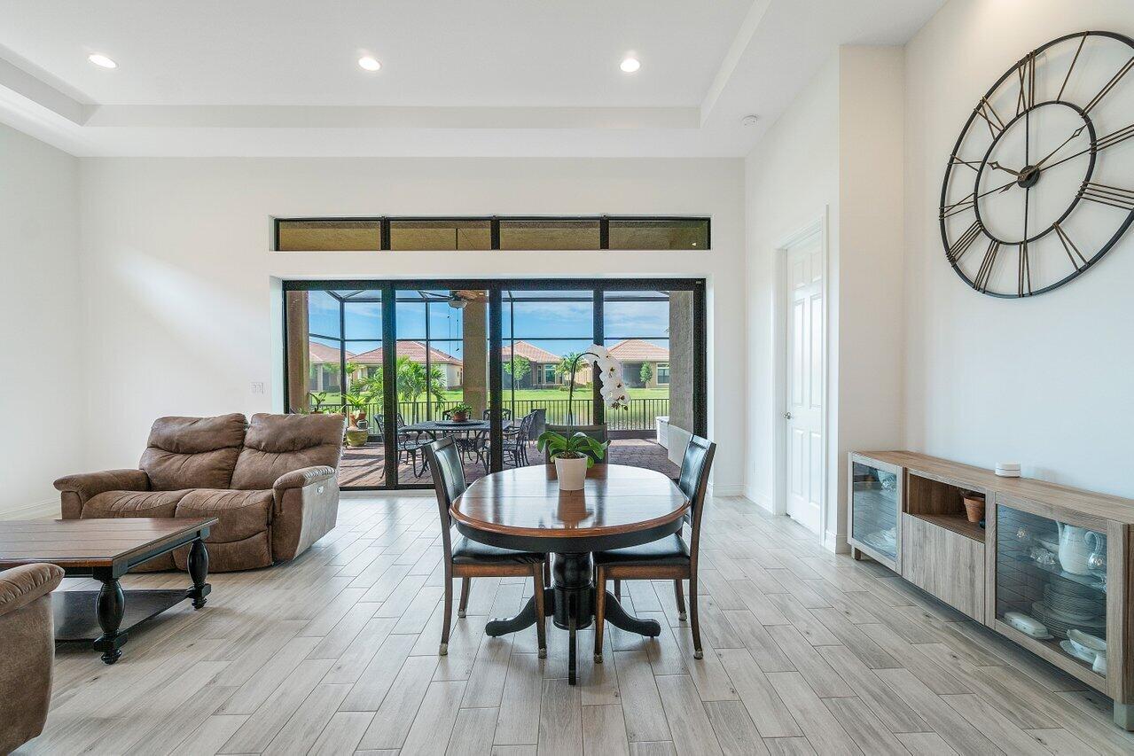 11856 Leon Circle Parkland, FL 33076 - Photo 4 of 43 a dining room with furniture a large window and wooden floor