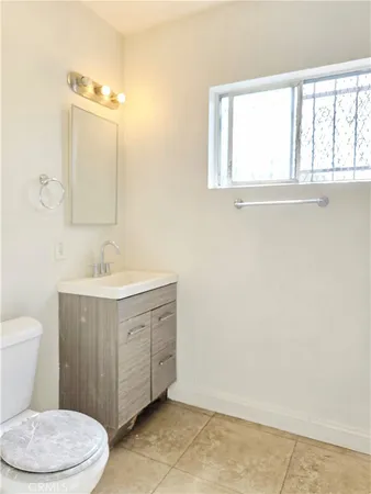a view of a livingroom with wooden floor and a bathroom