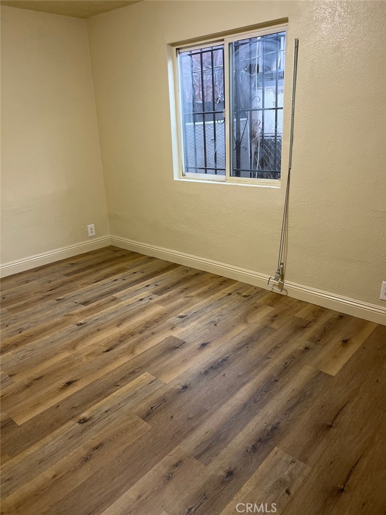 10529 Grape Street Los Angeles, CA 90002 - Photo 9 of 12 a view of an empty room with wooden floor and a window