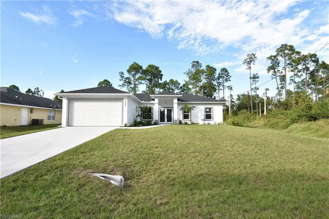 a front view of a house with a garden and yard