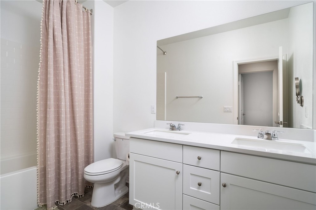 16502 Casa Grande Avenue, Unit 102 Fontana, CA 92336 - Photo 14 of 41 a bathroom with a granite countertop sink toilet and mirror