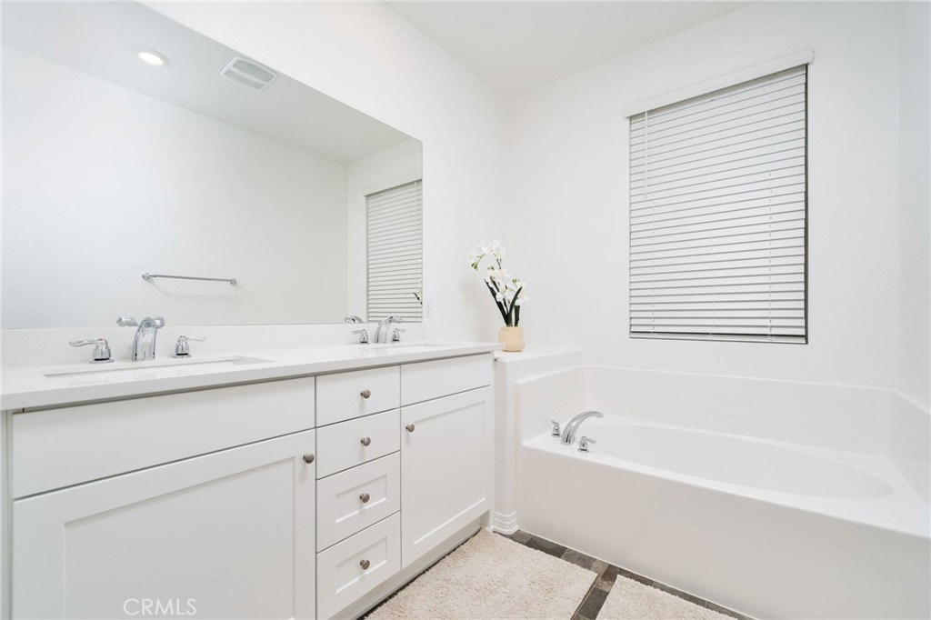 16502 Casa Grande Avenue, Unit 102 Fontana, CA 92336 - Photo 20 of 41 a bathroom with a bathtub sink double vanity and mirror